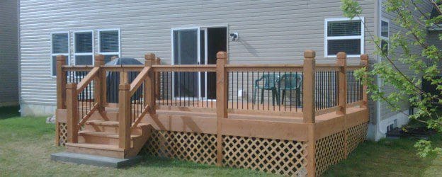 A deck with a wooden railing and steps.