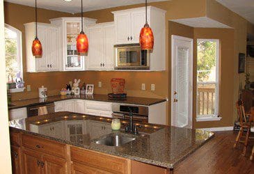 A kitchen with a center island and hardwood floors.