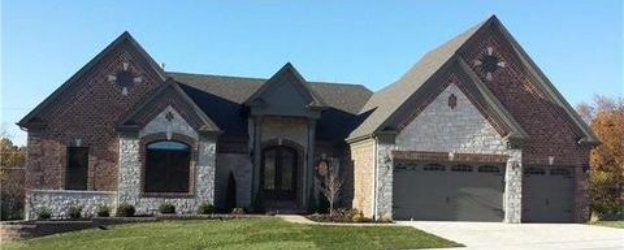 A brick home with a garage and driveway.