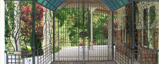 A wrought iron gate leading to a house.