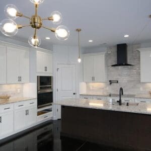 A Kitchen Remodel with white cabinets and a black island.