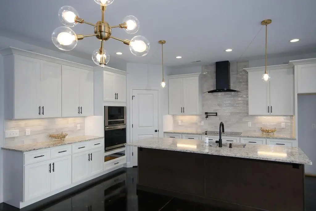 A Kitchen Remodel with white cabinets and a black island.