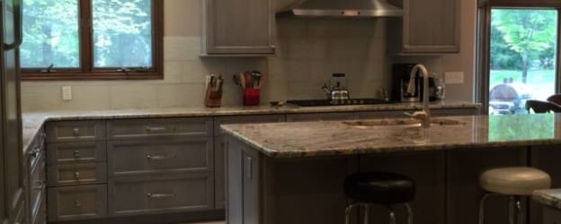 A kitchen with gray cabinets and counter tops.